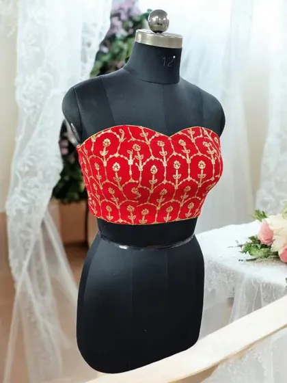 This red brocade bustier is a perfect example of our designer blouses. Whether you prefer ready-made styles or a custom fit, this piece adds a touch of regal charm to any ethnic ensemble.