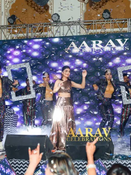 A daughter's stylish performance at Chomu Palace. The use of props like silver frames and a confetti shower adds a modern and fun twist to her Bollywood dance number.