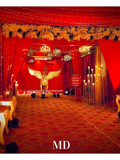 The grand entrance for a red and gold themed engagement party. A golden winged horse statue greets guests, setting a mythical and luxurious tone for the event.