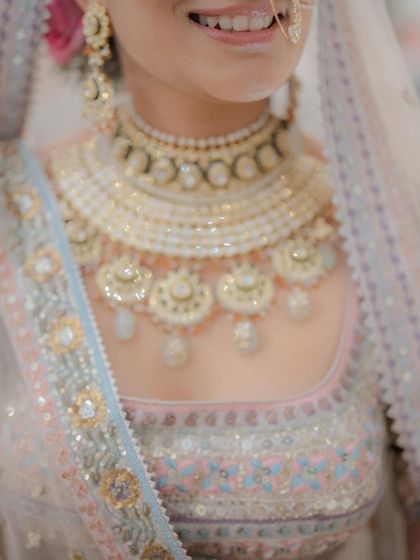 A close-up on the details. The soft pink eyeshadow and lip color perfectly pick up the tones in her pastel lehenga.