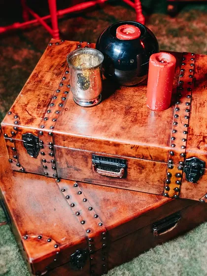 The details of our London Underground themed bar. We used vintage-style trunks as tables, accented with red candles and mercury glass votives to add to the moody, eclectic vibe of the cocktail night.