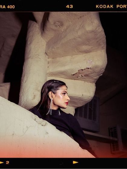 This image from the 'Embrace Self' shoot uses a Kodak Portra film effect. The model's pose on the spiral staircase creates a sense of intrigue and highlights the long, elegant lines of the styling.