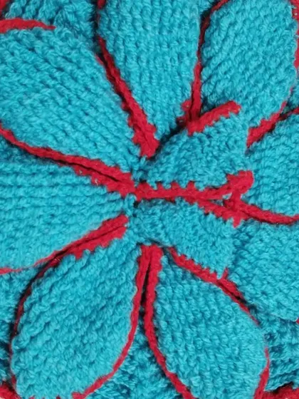 A beautiful flower-petal dress made with thick blue wool and outlined in red. This design is very warm and has a unique, layered look.