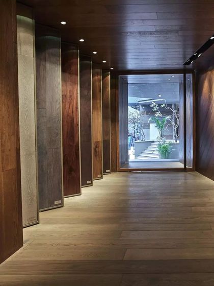 An 'experiential thoroughfare' at the FCML wood floor showroom in Delhi. This long, linear space allows customers to walk through and interact with over 200 types of wood flooring displayed in unconventional ways.