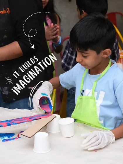 A young boy is completely focused on a fluid art project, pouring vibrant paints to create a unique abstract design. This activity is great for building imagination and exploring color mixing.