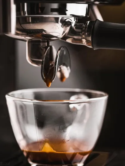 A macro shot of an espresso machine pulling a shot. I capture the precise moment the coffee drips, creating a dynamic and appealing image for coffee machine brands or cafes.