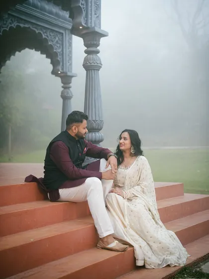 A wider angle of the couple relaxing on the steps of the gazebo set. This shot captures both the couple's interaction and the scale of the beautiful surroundings at my studio.