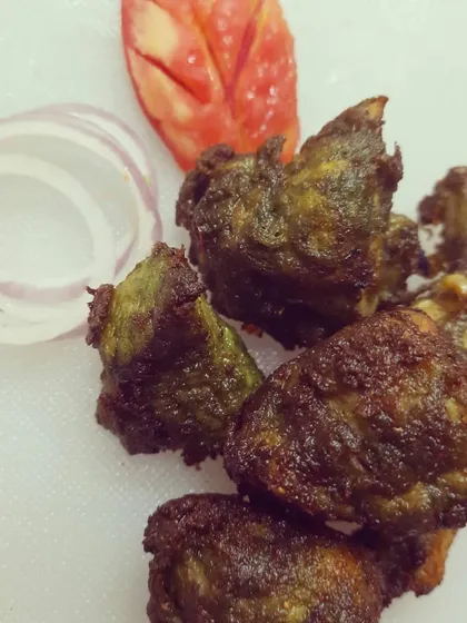 This is the Torpedo Chilli Kebab, a crowd favourite. It's a spicy fried chicken starter, tossed in a bold green chilli dressing that gives it a unique greenish-brown colour. A squeeze of lemon on top makes it perfect.