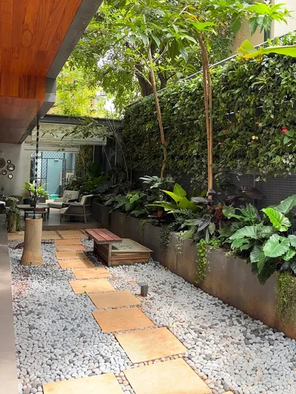 A pathway made of gravel and stone pavers creates a beautiful texture contrast in this garden. We used a mix of low-growing plants and taller trees to create a sense of discovery as you walk through the space.