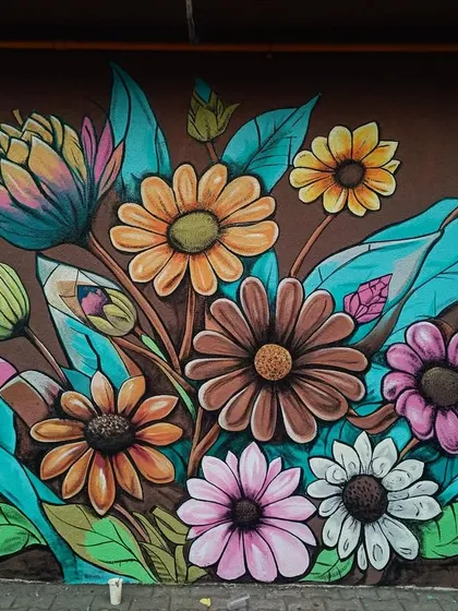 Another beautiful floral mural, this one featuring a different composition and color palette with earthy tones and bright blue leaves.