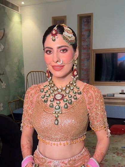 A portrait of the beautiful Anand Karaj bride, her hair neatly styled in a center-parted braid to complement her passa and maang tikka.