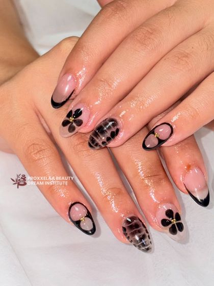 Ultra-glossy and ultra-elegant. This chic set combines a black French tip with black floral designs and a unique textured accent nail.