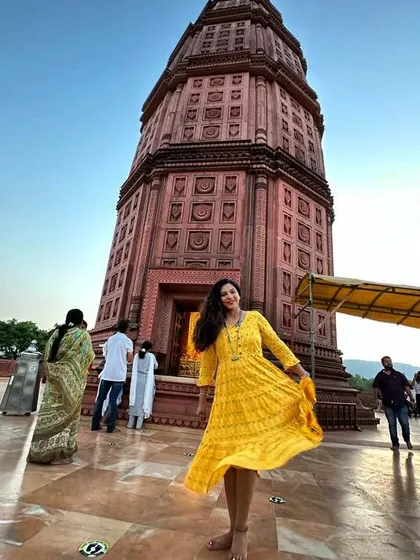 Here is another look at the yellow nursing-friendly dress, showing how the flared design provides comfort while the traditional print keeps it elegant. It's perfect for a day out or a peaceful visit to a temple.