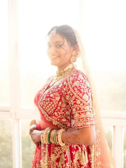 A beautiful, happy bride bathed in natural light. This photo captures the radiant and fresh feel of her wedding day makeup, designed to be timeless and elegant.
