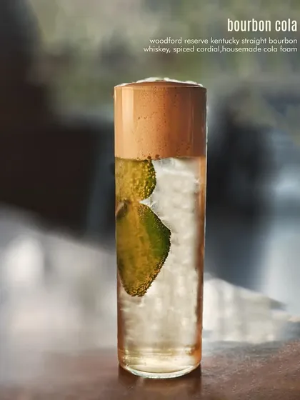 Our Bourbon Cola, elevated. We use Woodford Reserve, a spiced cordial, and a house-made cola foam to transform this simple mix into a sophisticated cocktail.