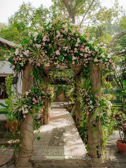 The bridge leading to the pavilion is decorated with a beautiful arch of flowers and greenery.