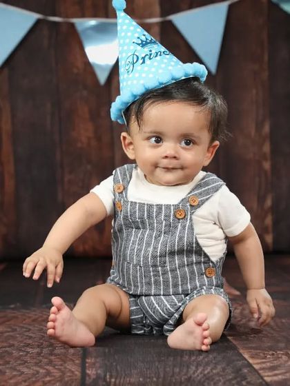 The birthday prince! A cute hat and a simple backdrop are perfect for capturing some classic portraits before the cake smash begins.