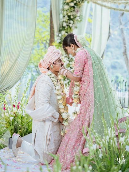 A repeat of image 358, a modern and respectful gesture as the groom bows down during the varmala.