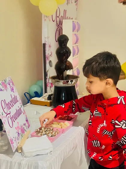 A young boy selects his favorite treats to dip into the warm chocolate fountain. We offer a delicious assortment to please every palate.