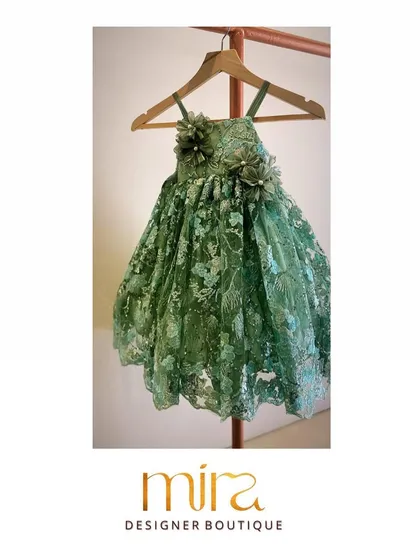 I designed this custom birthday dress in an elegant green net fabric for a client's daughter. The piece features intricate floral embroidery and delicate 3D flower appliqués on the bodice, creating a truly magical look for her special celebration.