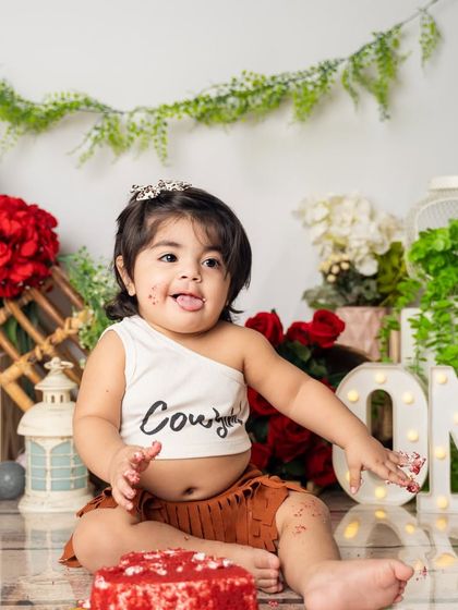 This little cowgirl is having a blast with her red velvet cake. We love the contrast of the rustic decor with the fun, messy cake smash.