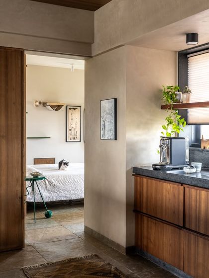 A view from the hallway into the guest bedroom, where you can see the cat-friendly shelves and the minimal, functional design. The space is designed to be personal and layered, reflecting the clients' creative personalities.
