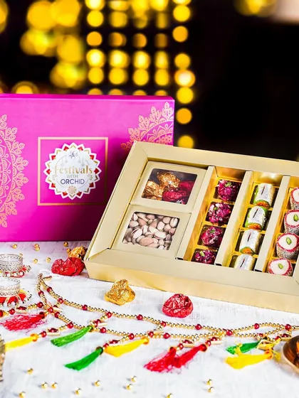 A premium Diwali hamper with a mix of dry fruits and sweets, styled with a traditional toran. The bright, festive colors and elegant packaging make it a perfect gift.