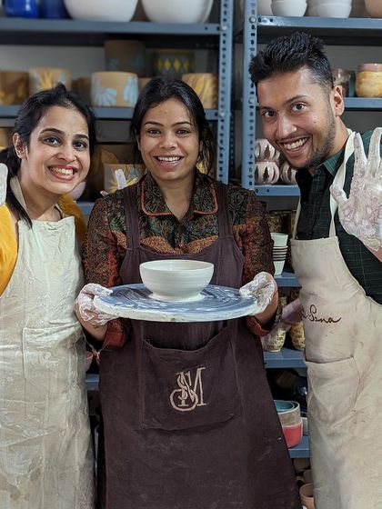 Success! This group proudly shows off the bowl and plate they created during a fun workshop.