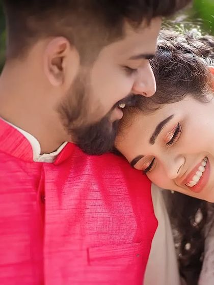 A tender and sweet moment. The bride rests her head on the groom's shoulder, her eyes closed in a happy smile. This is a perfect capture of trust, comfort, and affection.