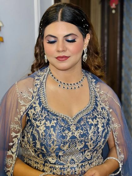 A close-up of a client ready for a reception or sangeet in a royal blue outfit. The bold blue eyeshadow is blended perfectly for a dramatic yet sophisticated look.