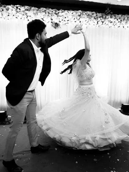 A beautiful black and white shot of the couple's first dance, with the bride's dress twirling elegantly.
