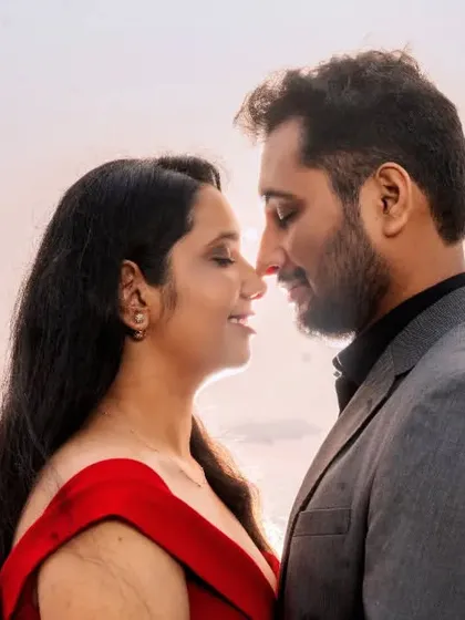 A close-up, intimate portrait with the soft, hazy light of the Mumbai shoreline in the background. The focus is entirely on the couple's connection and the romantic atmosphere.