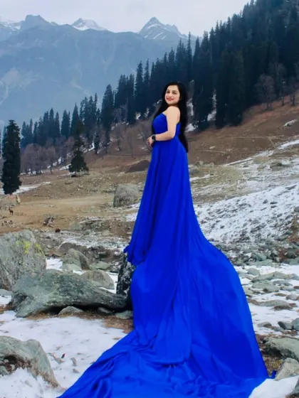 Our rental gowns can travel with you to create magic anywhere. This royal blue long-tail gown stands out beautifully against the snow, proving that a great outfit makes any location a perfect backdrop.