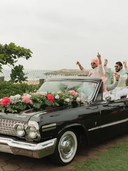 The groom and his squad make a grand entrance in a vintage Chevrolet convertible, driving along the Goan coast. It's all about making a statement.