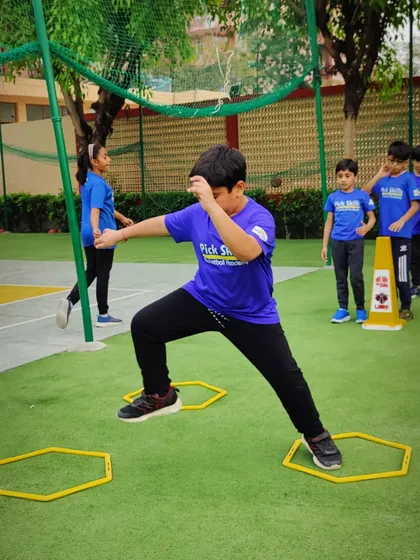 Focus and determination are visible as this young player executes an agility drill. We teach our players that consistent practice in these fundamental movements is the key to achieving their goals on the court.
