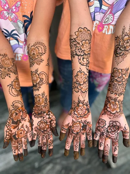 Mehendi for the whole crew! This photo shows coordinated floral designs for a group of friends or bridesmaids, a perfect activity for a bridal shower or sangeet.