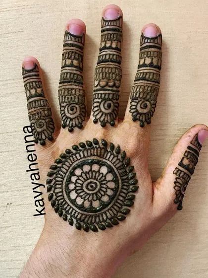 A classic mandala, or gol tikki, design on the palm. This minimalist style is complemented by detailed patterns on each finger, making it a popular choice for parties and festivals.