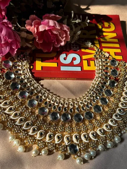 A stunning white Kundan necklace with intricate paisley-style Meenakari work. This piece is a work of art and is sure to make you the center of attention.