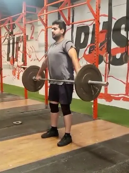 This lifter is at the top of the pull in a hang snatch, showing the powerful extension needed to elevate the bar.