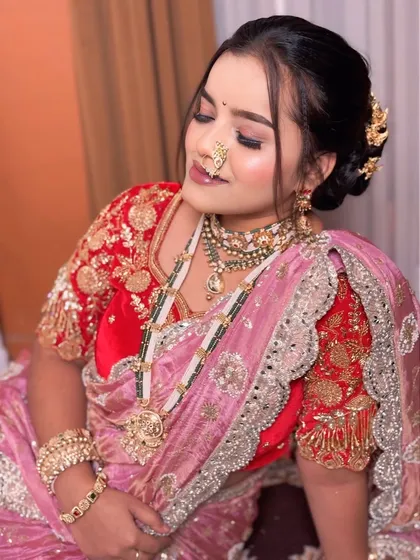 A close up of the bride's makeup and jewellery. The soft pink eyeshadow and the intricate design of the nath are the focus here.