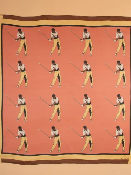 A flat-lay of a pink pocket square with a repeating golfer motif, showing the full pattern and color.