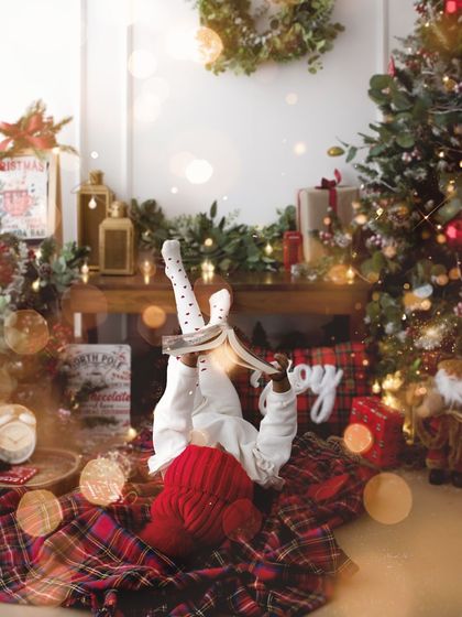 Lost in a good book amidst the festive decor. This creative shot captures the quiet magic and wonder of childhood during the holidays.