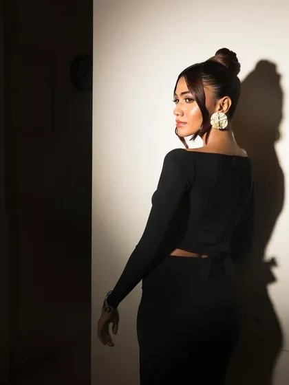 A full-body shot that plays with light and shadow. The makeup ensures her face is always the focal point.