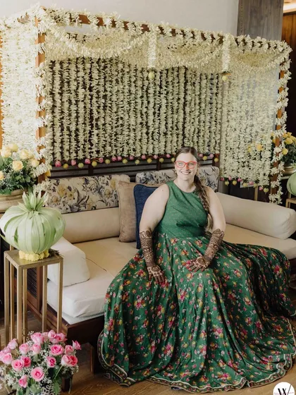 A beautiful Mehendi setup at home. We created a backdrop of white flower strings, providing a lovely, fragrant setting for the bride to get her henna done.