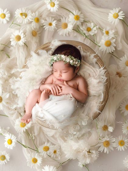 Another take on the daisy theme, this time with the baby posed to look like the center of a beautiful flower. It's a creative and artistic composition.