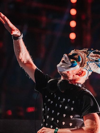 A powerful shot of Boris Brejcha raising his hand to the crowd, a master conductor of the night's energy.