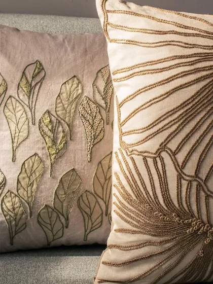 Another detail shot of our hand-embroidered cushions, showing the delicate interplay of different thread colors and textures. These cushions are perfect for creating a sophisticated, layered look.