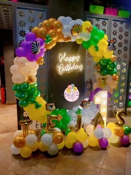 A jungle-themed birthday with a balloon ring, neon sign, and foil letters spelling out the name 'TEJAS'.