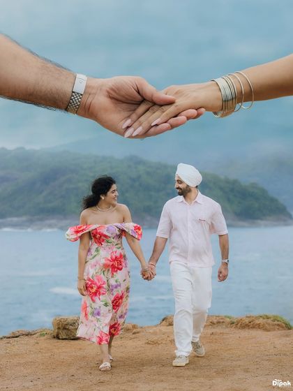 An artistic and symbolic pre-wedding photo from Thailand, with a close-up of the couple holding hands layered over a scenic shot of them walking by the sea.