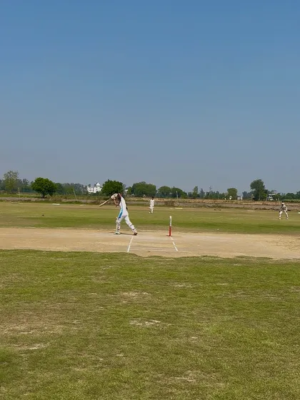 A wide shot of Aditi batting, showing her command at the crease.